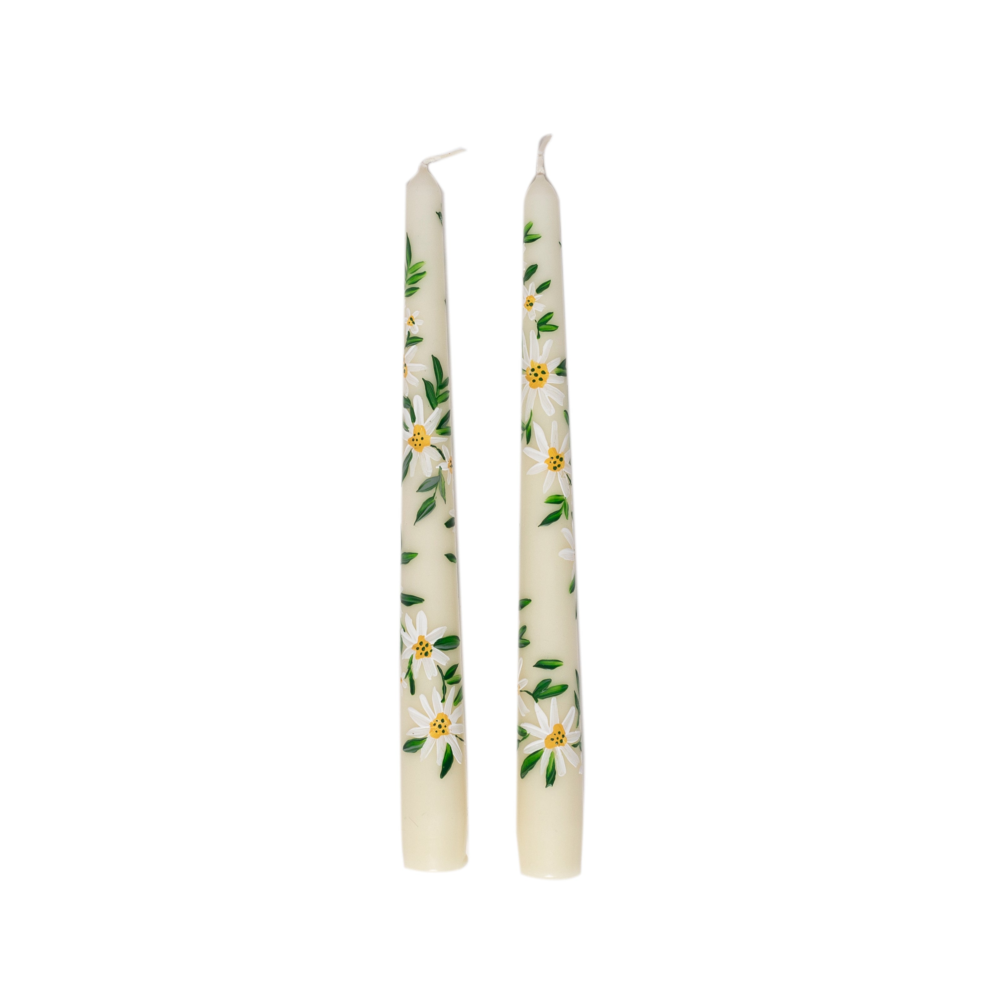 Two white candles with floral designs on a white background
