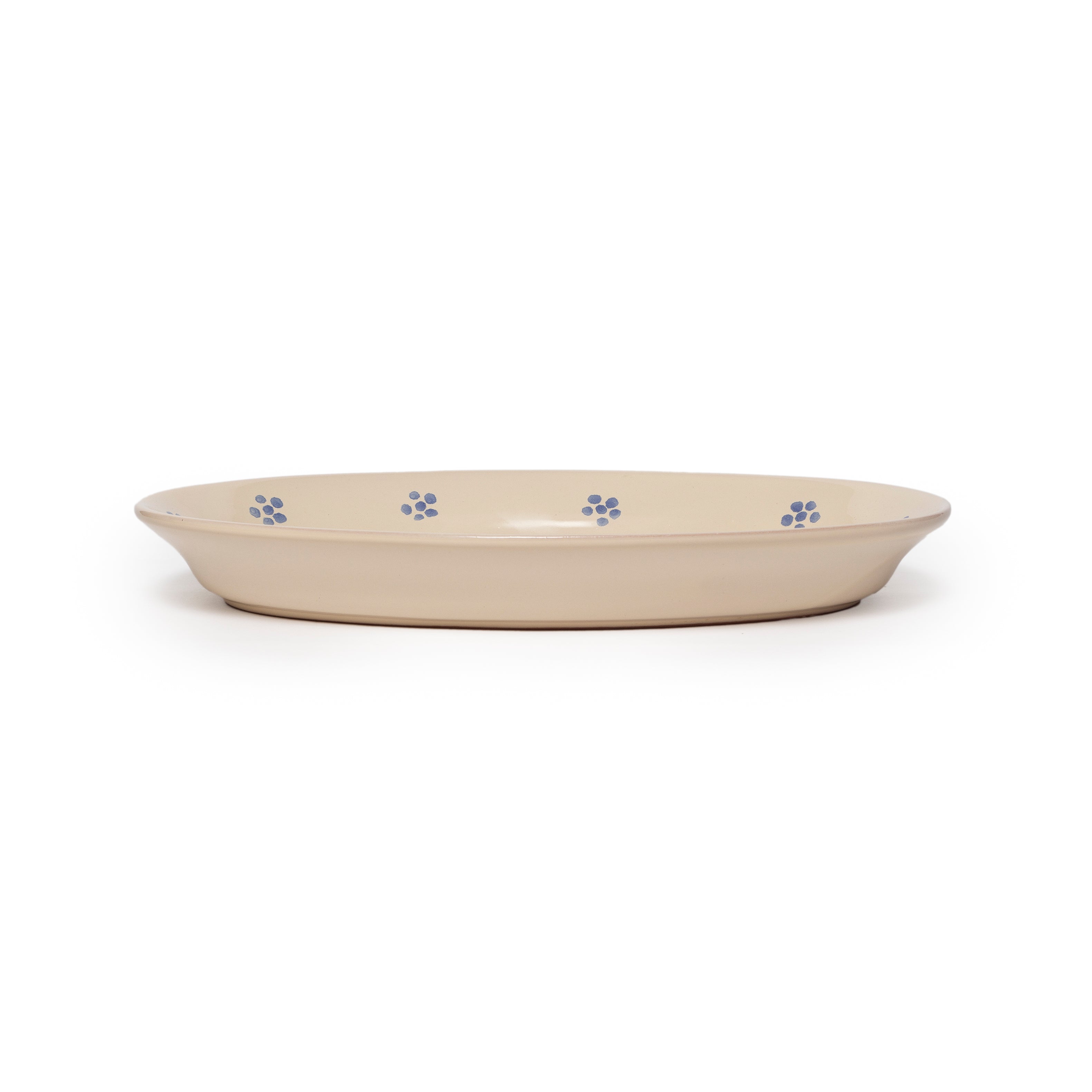 Beige ceramic dish with blue floral patterns on a white background