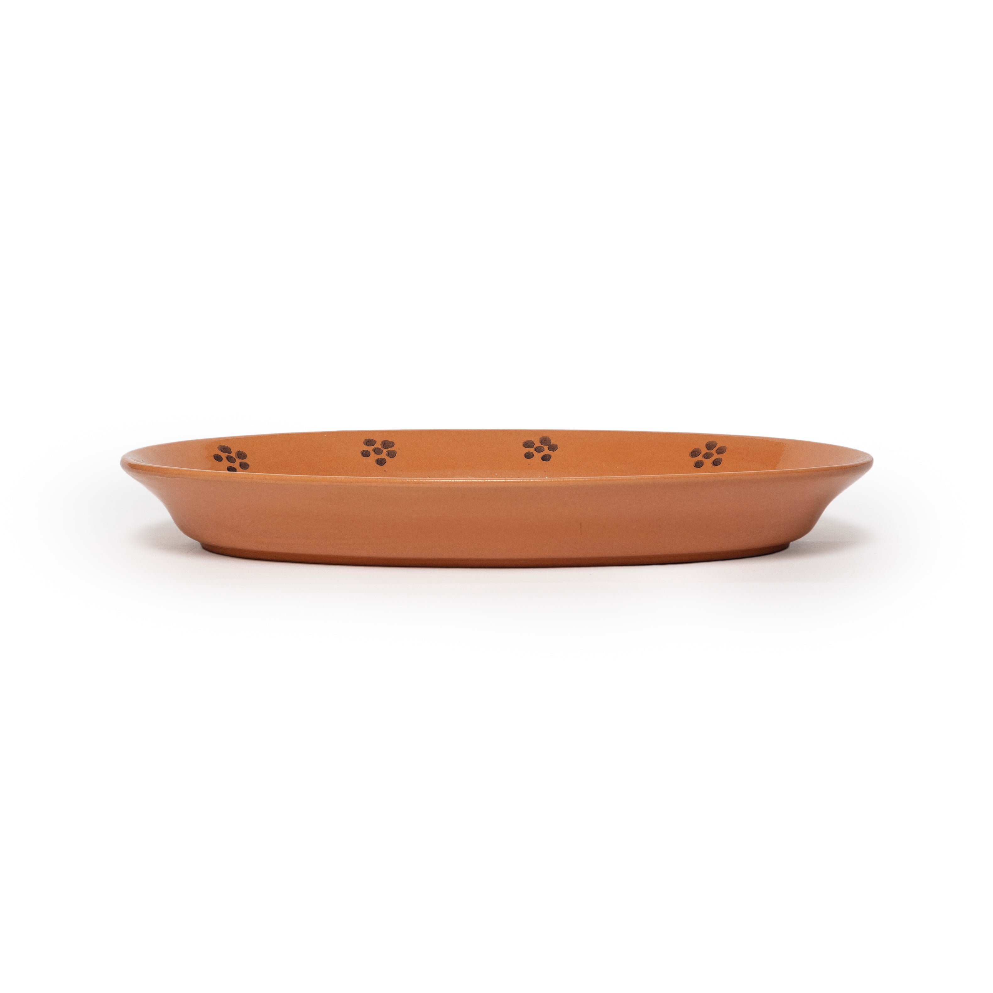 Terracotta-colored ceramic dish with floral designs on a white background