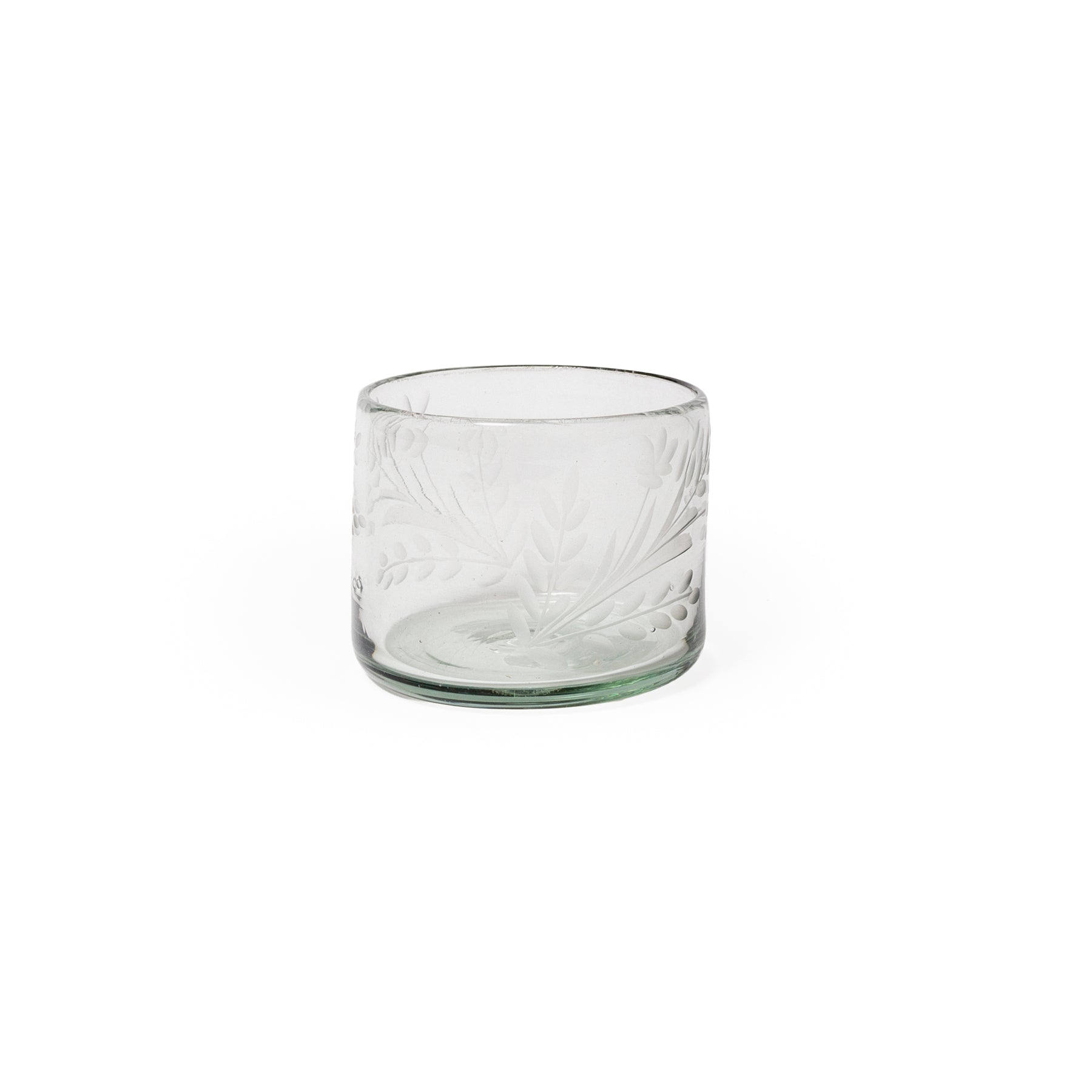 Clear glass tumbler with embossed design on a white background