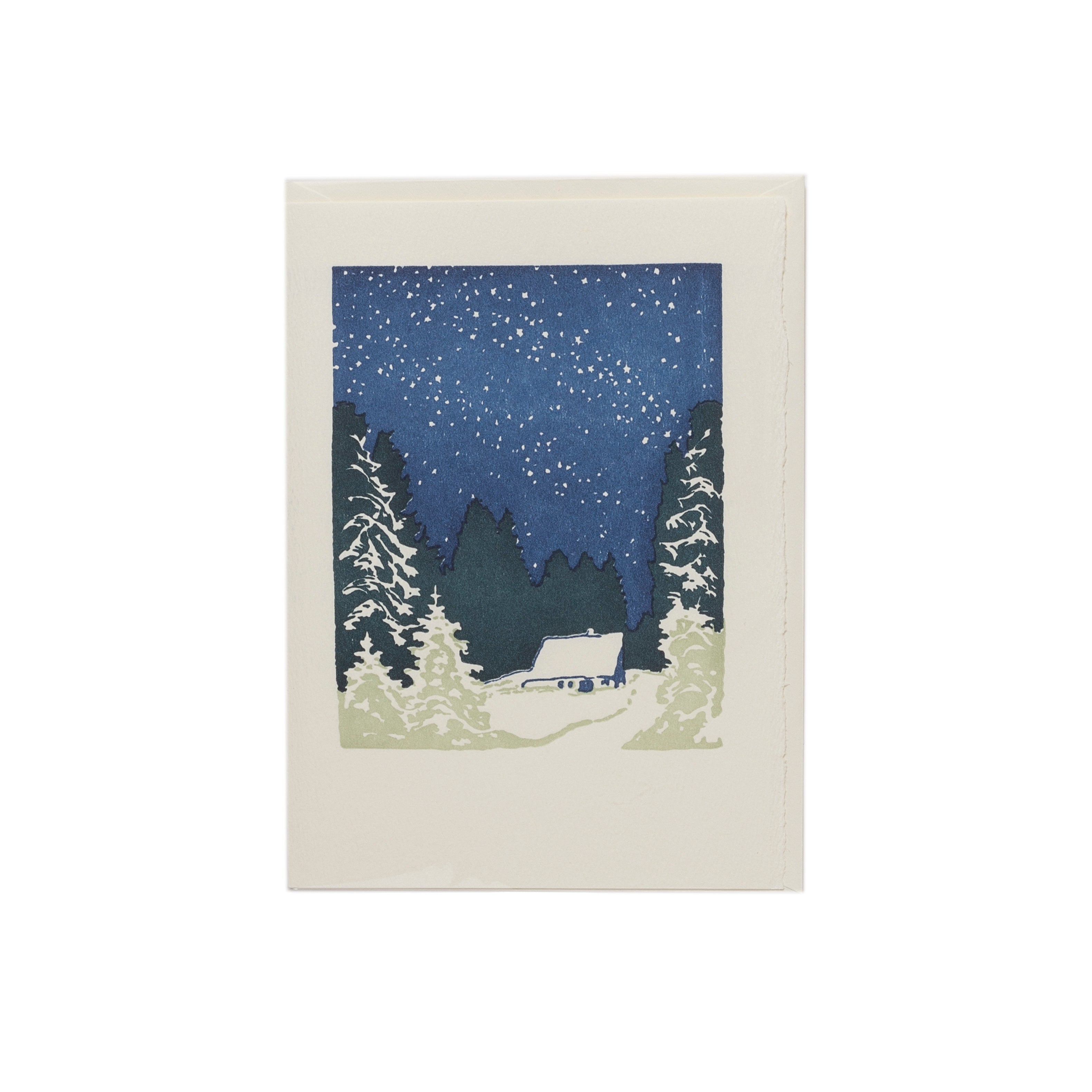 Card with snowy landscape with trees and a house under a starry night sky.