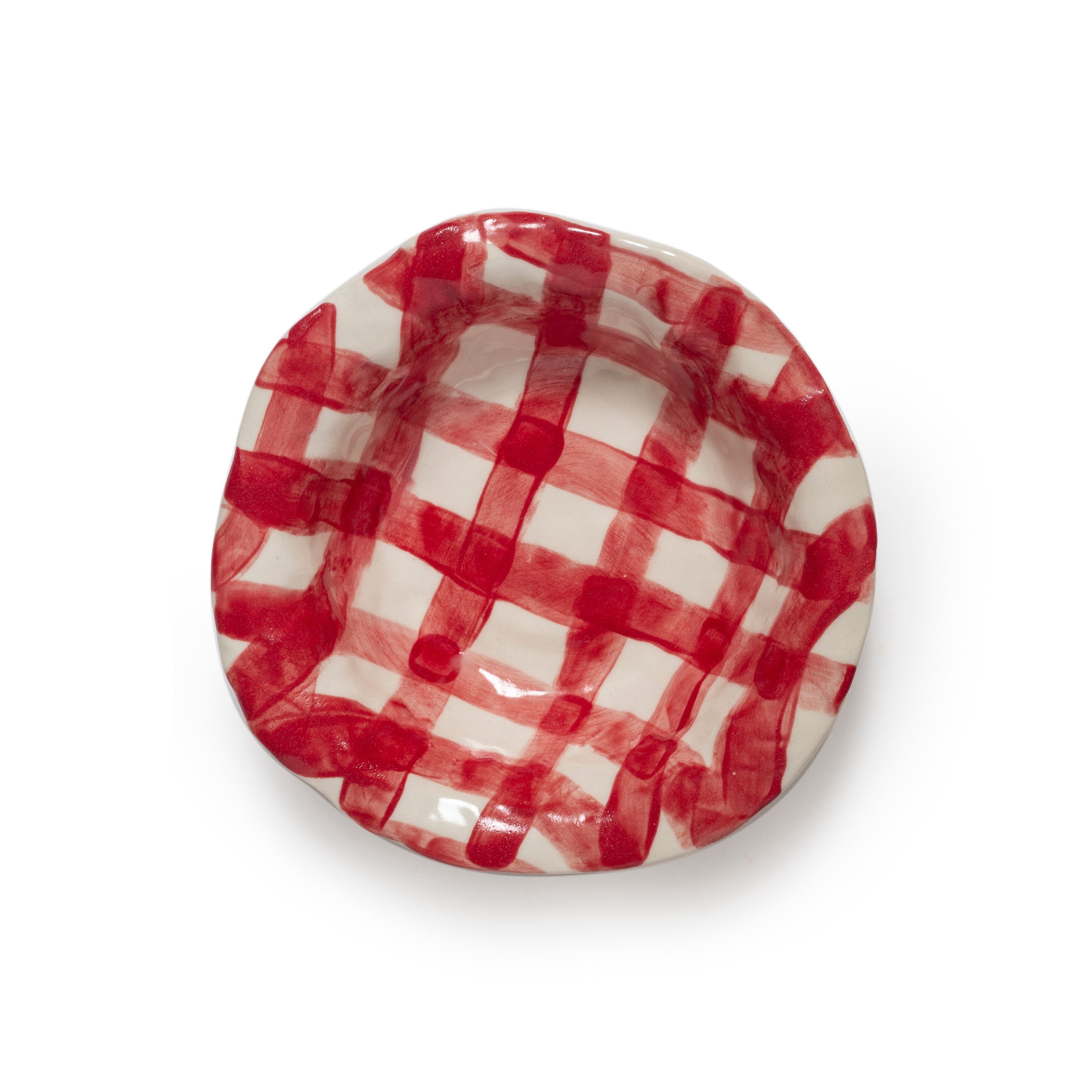 Red and white gingham ceramic dish on a white background