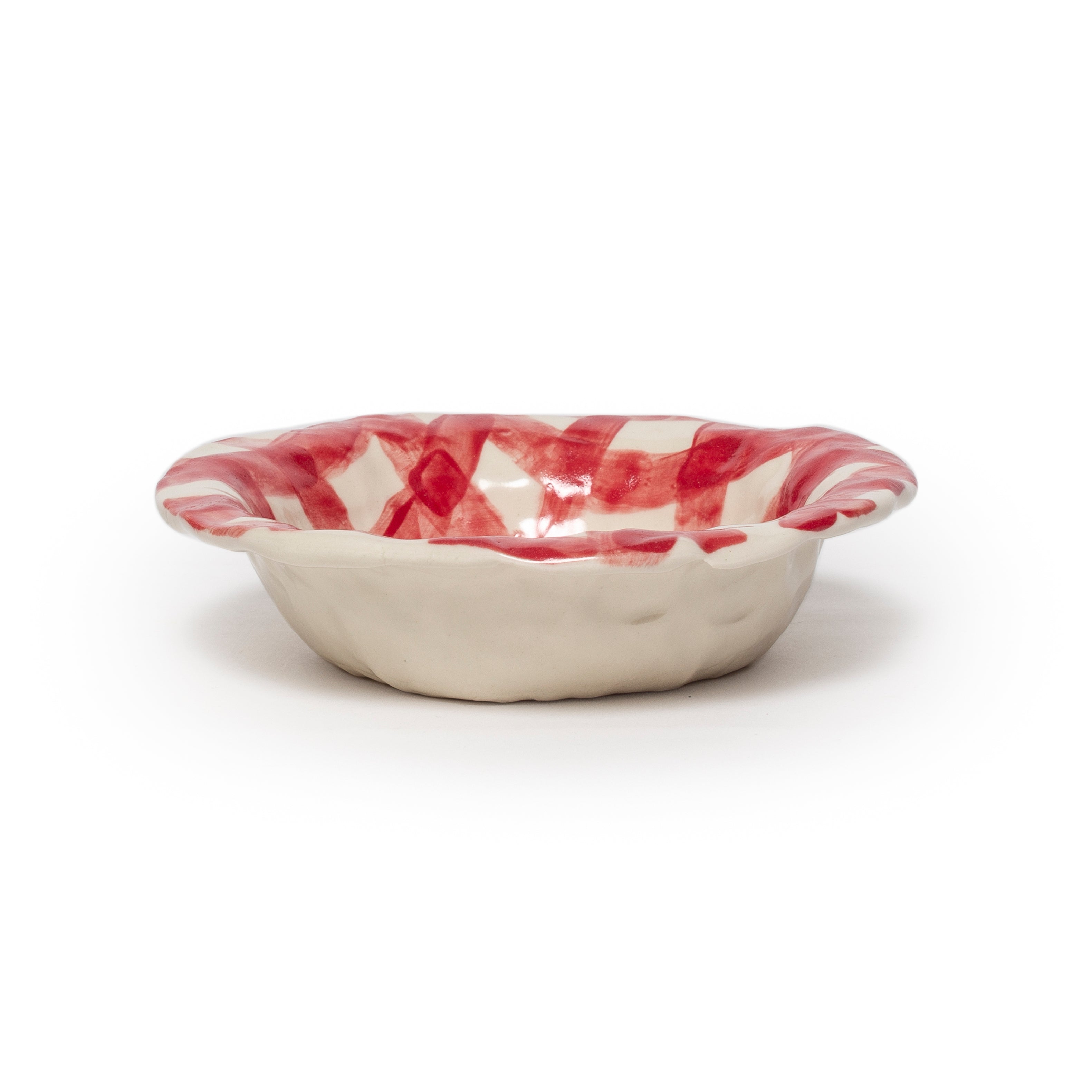 Ceramic bowl with red and white striped interior on a white background