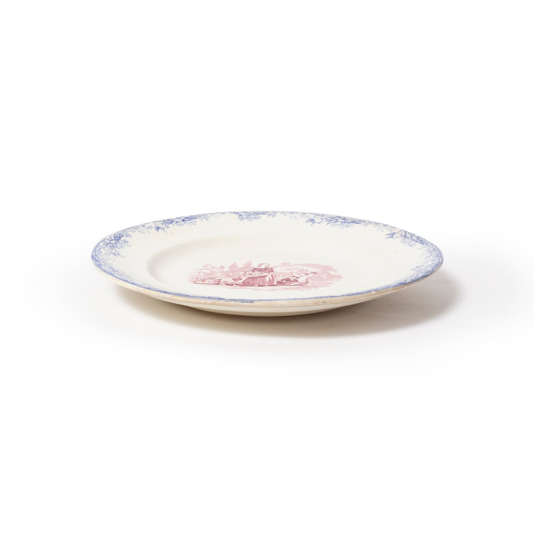 White ceramic plate with blue rim and red floral design on a white background