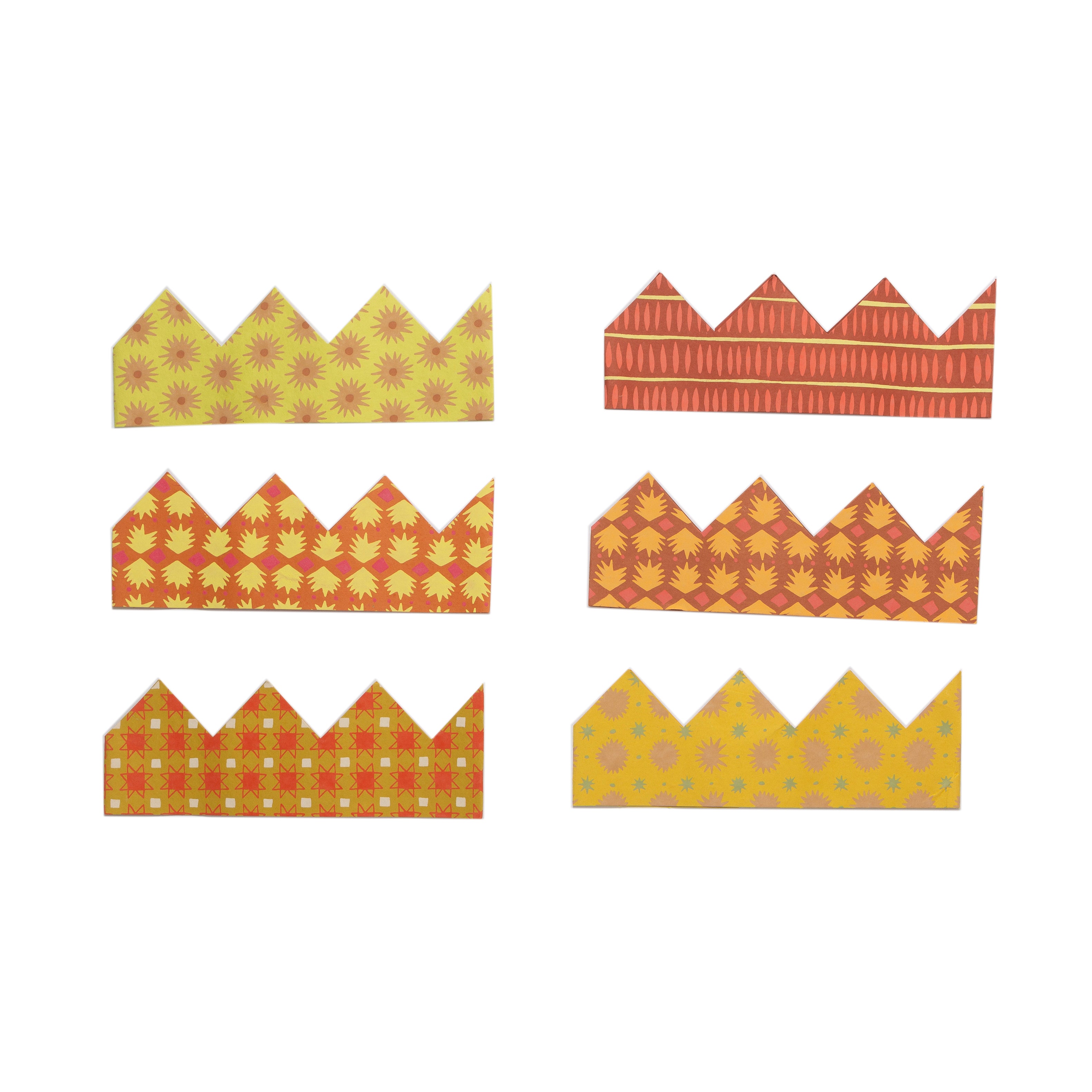 Set of six patterned paper crowns on a white background