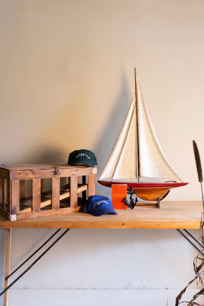 Hats and model sailboat on table