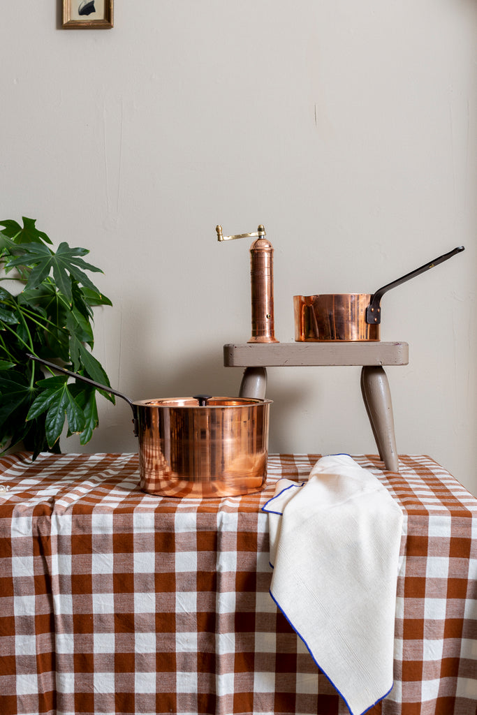 Copper kitchen items on gingham tablecloth